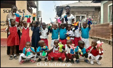Photograph: Children of the Little Faces School in Mobasa, Kenya, smile with pleasure waving their teddies from Lutterworth in the air.
